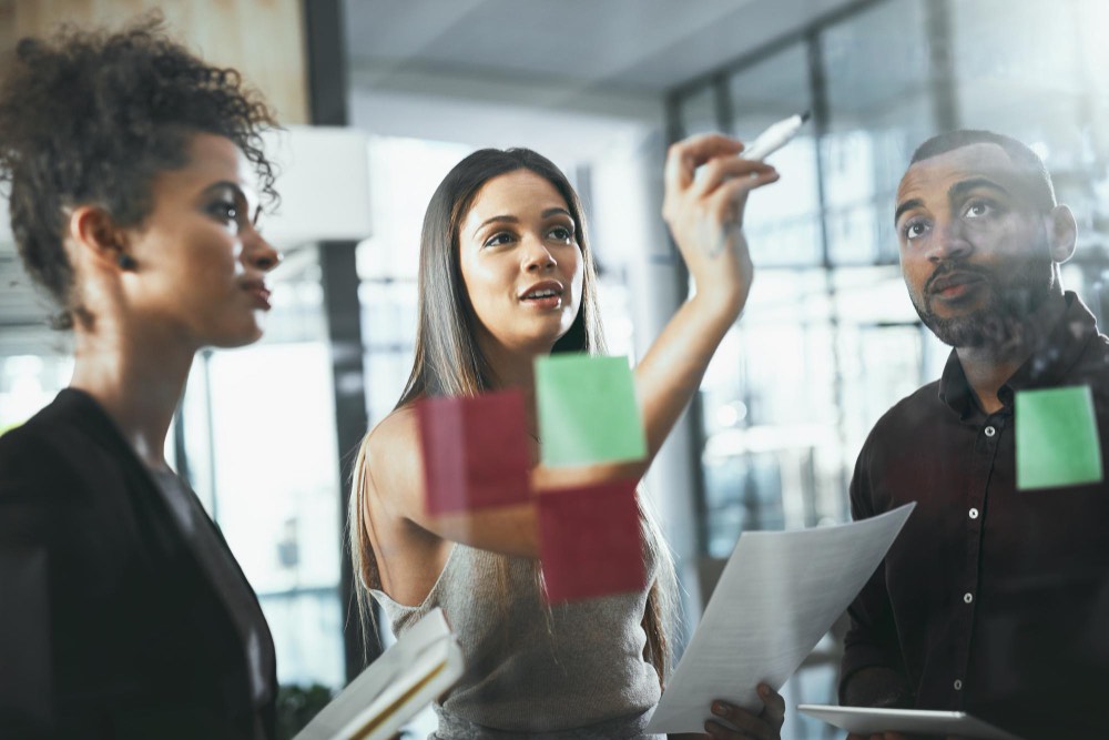 Three professionals collaborating in a modern office, depicting the process of selecting effective diversity and inclusion consultants.